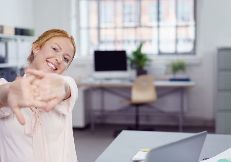 Young woman stretching her hands in the office