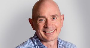 Bald man with blue eyes is smiling