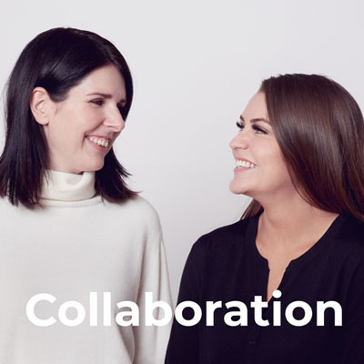 Two women are standing side by side, smiling at each other against a plain background. The word "Collaboration" is written in large white letters at the bottom of the image.