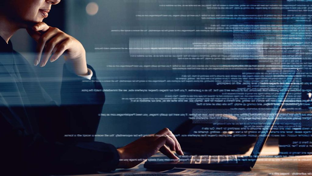 A person sits at a desk, focused on a laptop. They are partially visible, with a hand on their chin. Digital code overlays the image, suggesting programming or cybersecurity work in progress.